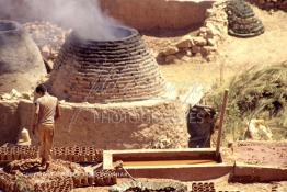 Image du Maroc Professionnelle de  Un ouvrier pétrit l’argile imprégnée d’eau dans les ateliers de la Vallée Chaâba près des fours où l’on procède à la cuisson des poteries en céramique à Safi, Souvent les artisans ont recours à leur dextérité afin de fignoler la décoration à Safi, Samedi 30 Août 1997. (Photo / Abdeljalil Bounhar) 